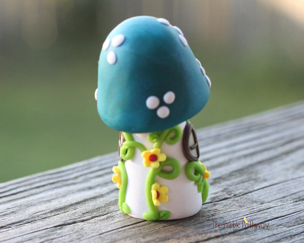 Tiny Blue mushroom gnome home with yellow flowers and vines